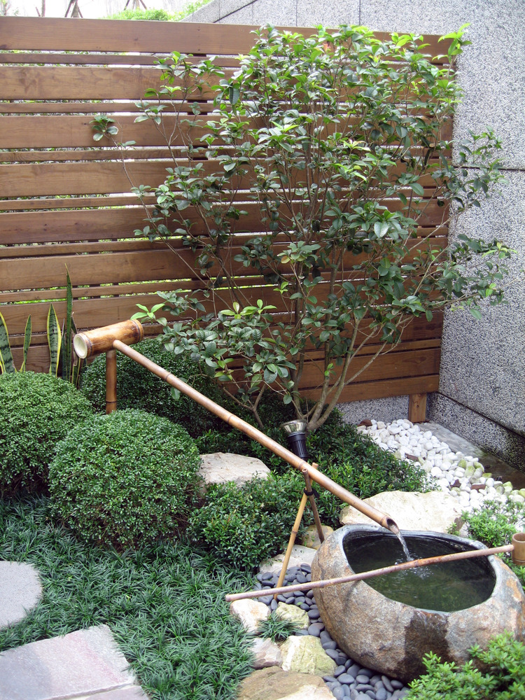 自然青石水缽搭配竹流水與圓雪見石燈點綴的日式庭院氛圍